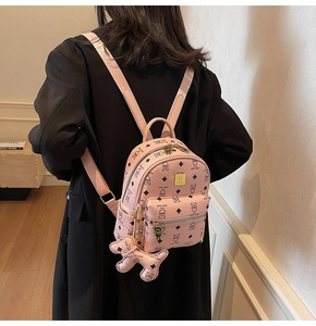 Detailed view of pink monogram backpack with teddy bear pattern and matching charm