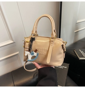 Detail of beige leather Boston bag featuring MUHETI SHI SHANG embossed letters and pony charm