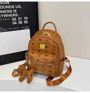 Detail of tan leather backpack with black bear pattern and golden zipper and hardware