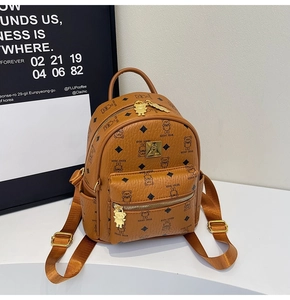 Close-up of brown PU backpack featuring teddy bear pattern and golden bear-shaped zipper