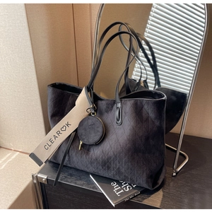 Detail of black matte tote bag featuring diamond quilted texture and heart-printed strap
