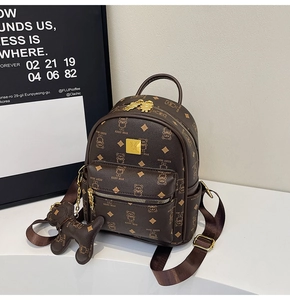Detail of Keddy Bear mini backpack featuring bear print and golden logo plate with charm