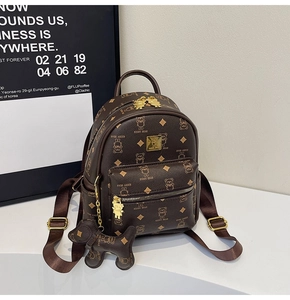 Detail of dark brown mini backpack with bear monogram pattern and gold bear zipper pull