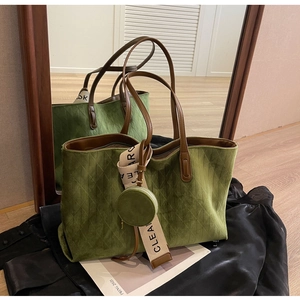 Detail of green suede tote bag with diamond quilting and decorative hanging charms