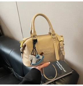 Detail of trendy retro shoulder bag with embossed letters and cute blue horse charm