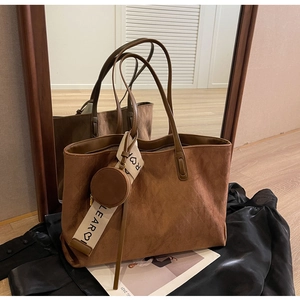 Detail of vintage brown suede tote bag with ribbon and small coin purse attachment