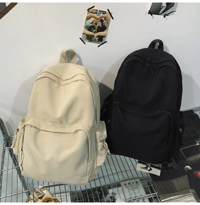 Detailansicht von beigen und schwarzen Canvas-Rucksäcken auf einem Metallregal