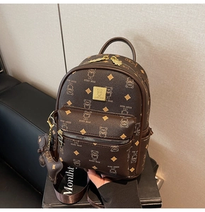 Detailed close-up of brown PU leather backpack with bear prints and golden logo plate