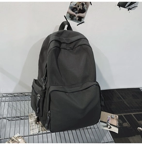 Detailansicht des dunkelgrauen Nylon-Rucksacks mit Multi-Taschen-Design und Reißverschlüssen