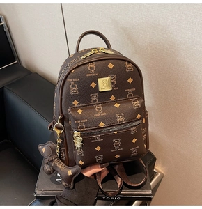 Close-up of brown synthetic leather backpack featuring bear pattern and metal logo detail