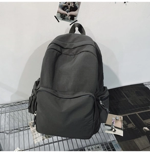 Detailaufnahme eines dunkelgrauen Nylonrucksacks mit Reißverschlusstaschen am Metallgestell