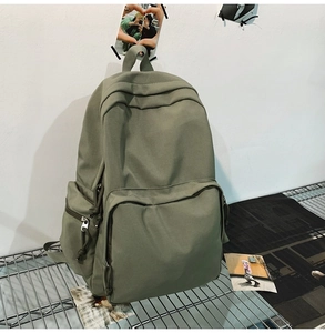 Nahaufnahme eines olivgrünen Rucksacks mit Reißverschlusstaschen auf Metallgestell