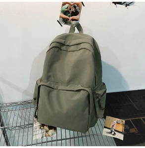 Detailansicht eines olivgrünen Canvas-Rucksacks auf einem Metallregal mit Ästhetik