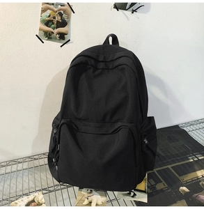 Nahaufnahme eines schwarzen minimalistischen Nylon-Rucksacks mit Fronttasche auf Metallregal