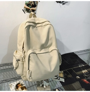 Detailansicht beige Leinwand Rucksack mit Multi-Taschen-Design auf Gitterregal