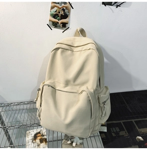 Detailansicht des cremeweißen minimalistischen Canvas-Rucksacks mit Reißverschlusstaschen