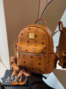 Brown leather backpack with teddy bear prints and metallic bear charm detail