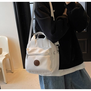 Detail of white nylon crossbody bag with adjustable strap and brown leather bike logo