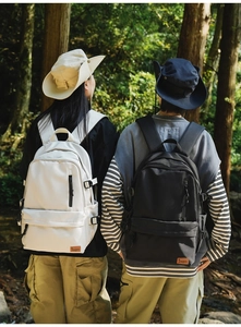 Outdoor backpacks in cream and black featuring multi-pockets and side buckle detail