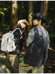 Outdoor lifestyle view of minimalist black and beige backpacks with side buckles