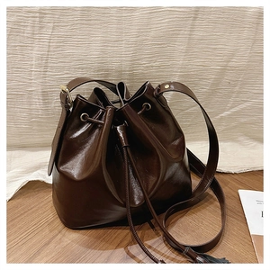 Détails du sac seau marron foncé avec cordon de serrage et finitions dorées