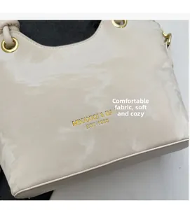 Detail shot of cream bucket bag with gold logo and premium metal eyelet texture