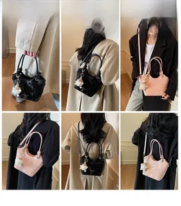 Detail showing women's bucket bag in black and pink with a cute sheep plush charm