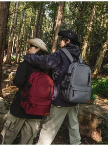 Detail of waterproof nylon backpack with adjustable side straps in outdoor forest setting