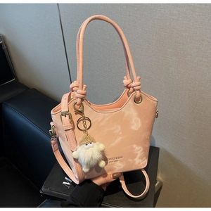 Detail of pink marble textured bucket bag with fluffy white charm and knotted handle