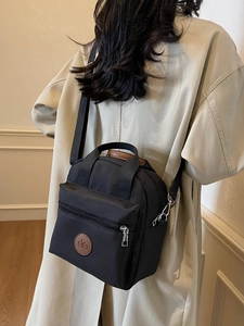 Black washed nylon crossbody bag for women featuring brown leather trim and shoulder strap