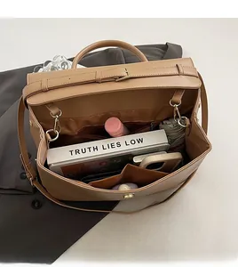 Top view showing large capacity interior of khaki leather briefcase with a tablet and book