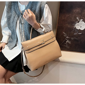 Detail of light brown leather satchel showing buckle closure and spacious structure