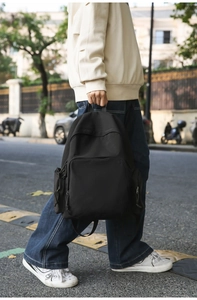 Détails du sac à dos noir minimaliste avec poches zippées et texture en nylon fin