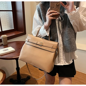 Detail of vintage faux leather handbag with metal buckle and adjustable shoulder strap