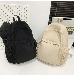 Sacs à dos minimalistes en nylon noir et beige présentés côte à côte en studio