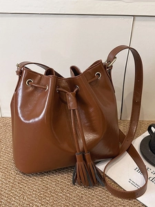 Sac seau vintage en cuir marron avec cordon de serrage, glands et détails dorés