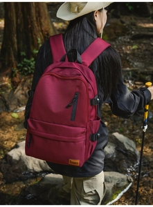 Close-up of deep wine red outdoor backpack featuring adjustable buckles and brand patch