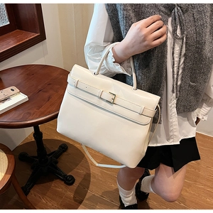 Detail of white leather briefcase bag with gold hardware and stylish buckle strap design