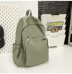 Vue détaillée d'un sac à dos en nylon vert sauge avec grande poche et rangement latéral