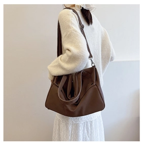 Λεπτομέρεια vintage καφέ τσάντα tote με ρυθμιζόμενα λουριά και μεταλλικά καρφιά