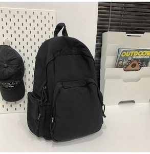 Détail du sac à dos en nylon noir avec design multipoches et tirettes tressées