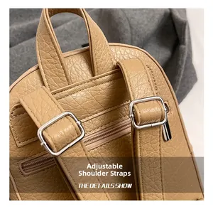 Detail of khaki leather backpack featuring adjustable straps and hidden back zipper pocket