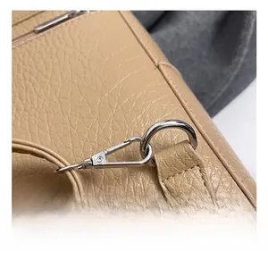 Close-up of premium metal hook and D-ring on pebbled leather travel backpack detail