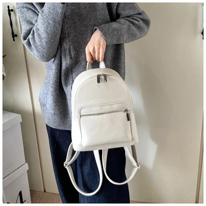 Close-up of white pebble grain leather mini backpack with silver metal zipper details