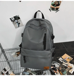 Close-up of grey textile backpack featuring the TENGRUN brand label and functional zippers