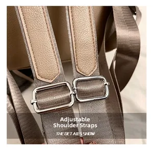 Close-up of adjustable khaki leather shoulder strap with silver metal buckles on a backpack