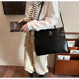 Detail of a black vintage briefcase bag with metallic buckle and flap closure
