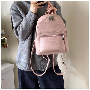 Detailed shot of pink pebble leather backpack showing premium texture and silver zippers