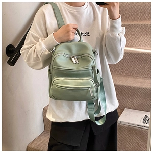 Detail showing litchi grain texture and silver zipper of sage green mini backpack