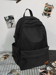 Large black minimalist laptop backpack with multiple pockets on a metal rack